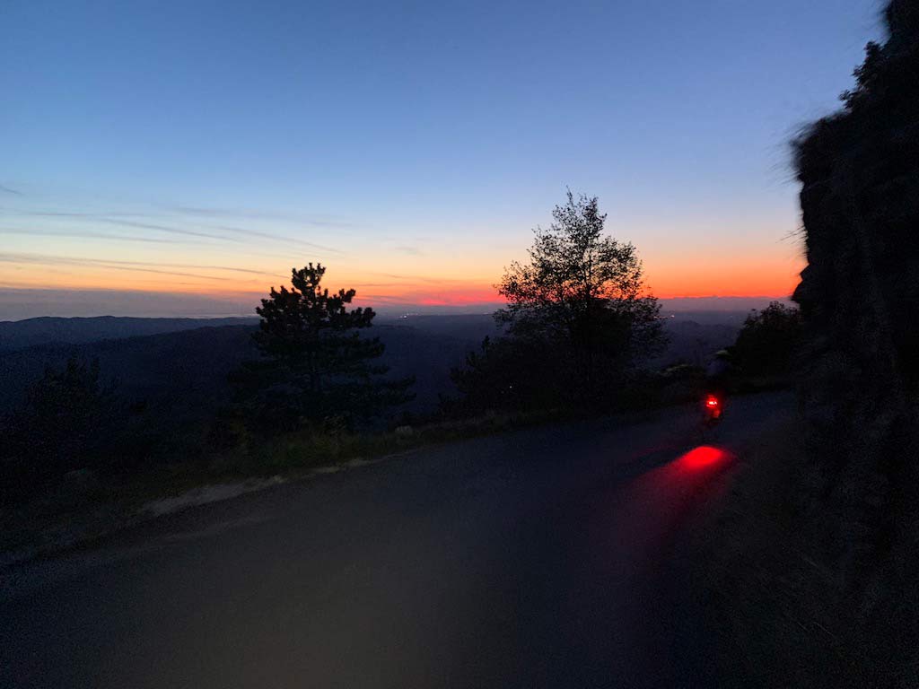 sunset view riding down a switchback road off nanos plateau in slovenia