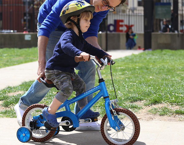 Priority bicycles Start kids bike,  dad guiding kid