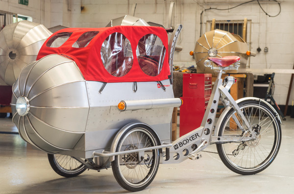 BNPS.co.uk (01202 558833) Pic: PhilYeomans/BNPS Back to the future..with its rain hood up. Retro style electric trike a cross between Jules Verne and Flash Gordon is turning heads on the south coast.  A dad of two is hoping his bike business takes off after launching these stunning electric tricycles inspired by 1930s aeroplanes.  Jeremy Davies designed the incredible three-wheeled machine so he could cart his young children Eve and Sid back and forth to the beach near his home town of Poole, Dorset. But he turned so many heads with his one-of-a-kind vehicle that he decided to go into business - and the wacky trikes have been flying off the shelves since going on sale last month. However anyone wanting to get their hands on one will need deep pockets - because they come with a hefty £4,950 price tag.