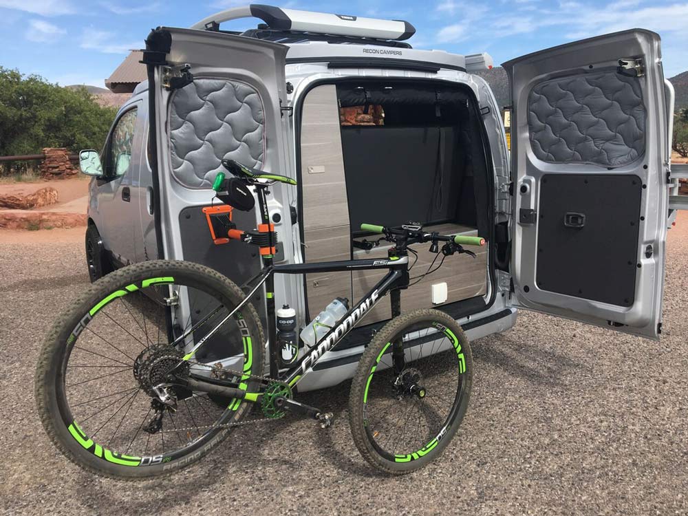 internal bicycle workstand for a camper van from recon campers fits inside a nissan NV200 cargo van