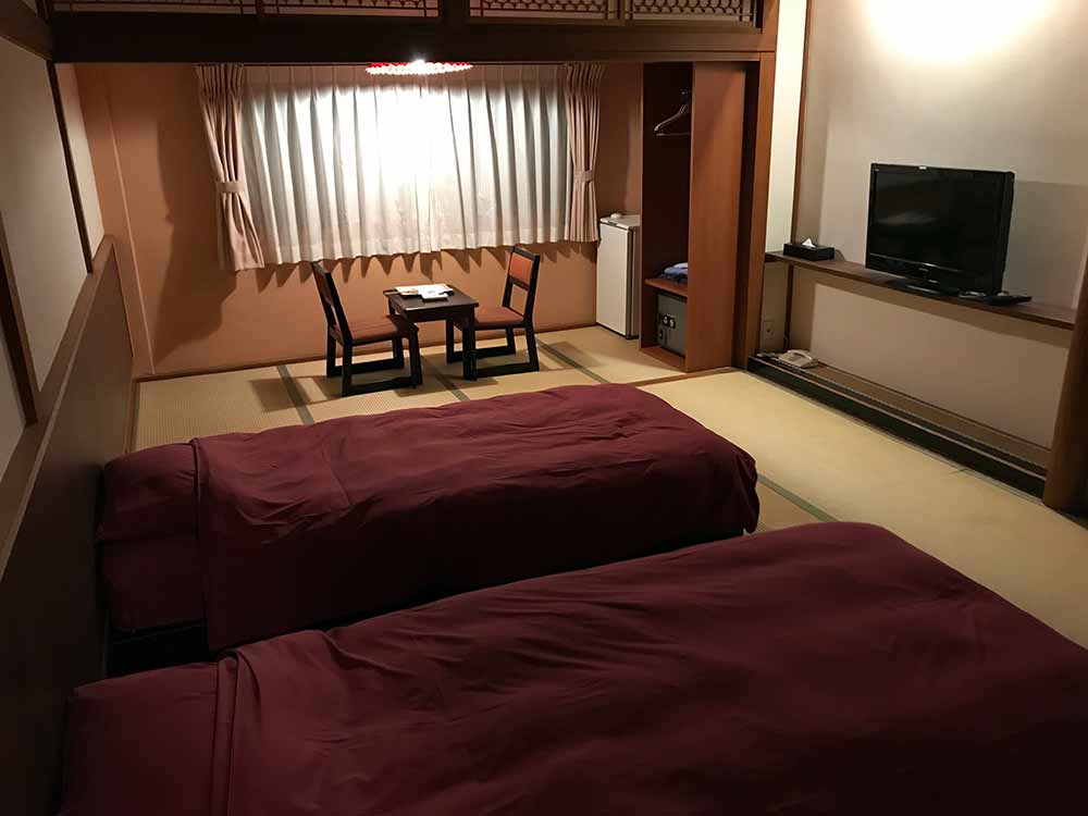 A traditional Japanese hotel room with tatami mat flooring. Beds are optional in some rooms.