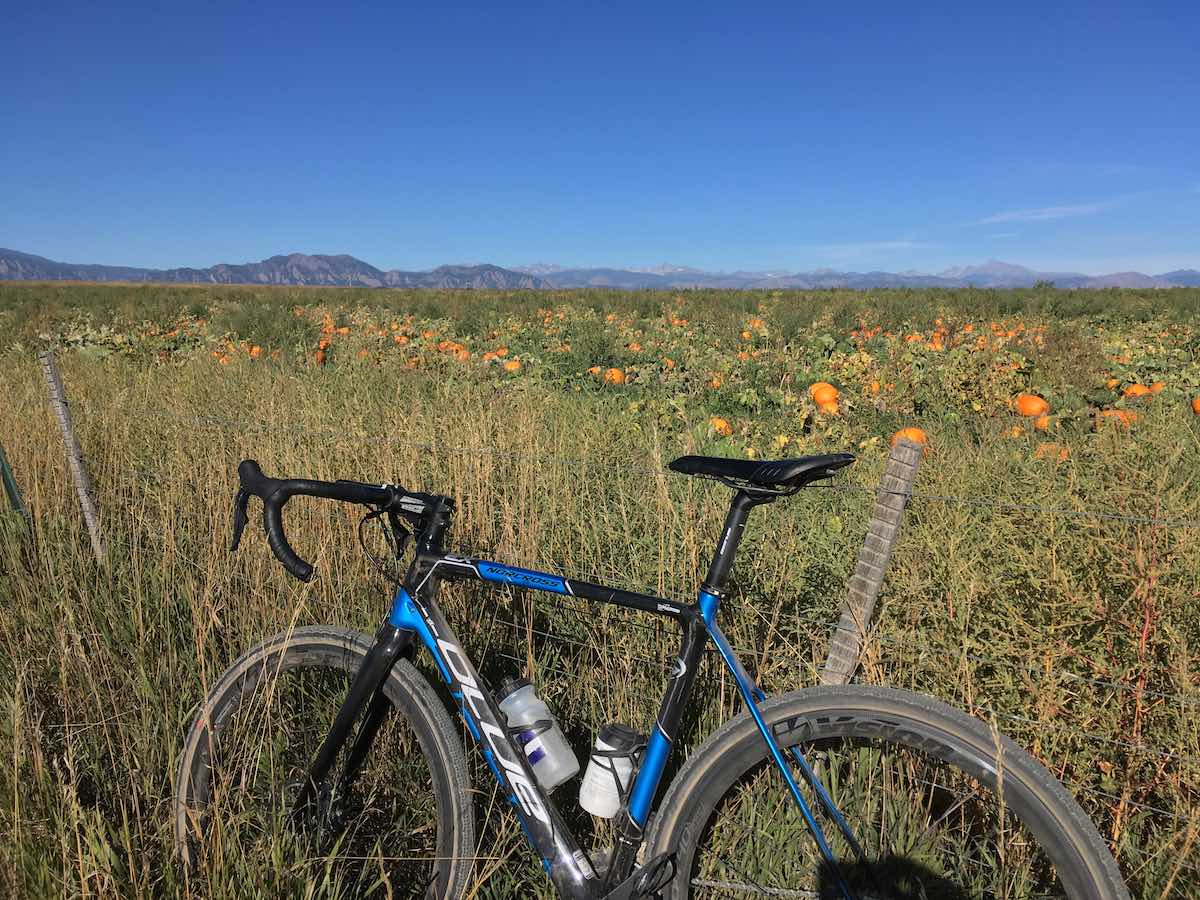 bikerumor pic of the day blue and black road bike in front of pumpkin patch with the flatiron mountains in the horizon. Louisville, Colorado, near Boulder.