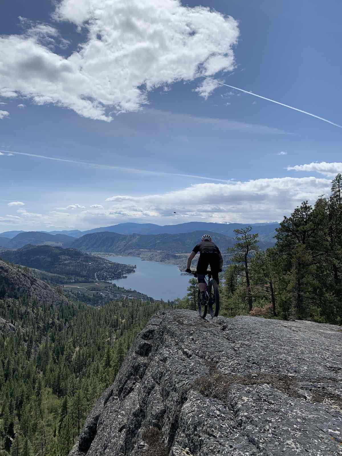 bikerumor pic of the day cyclist on top of rock overlooking Okanagan valley in British Columbia.