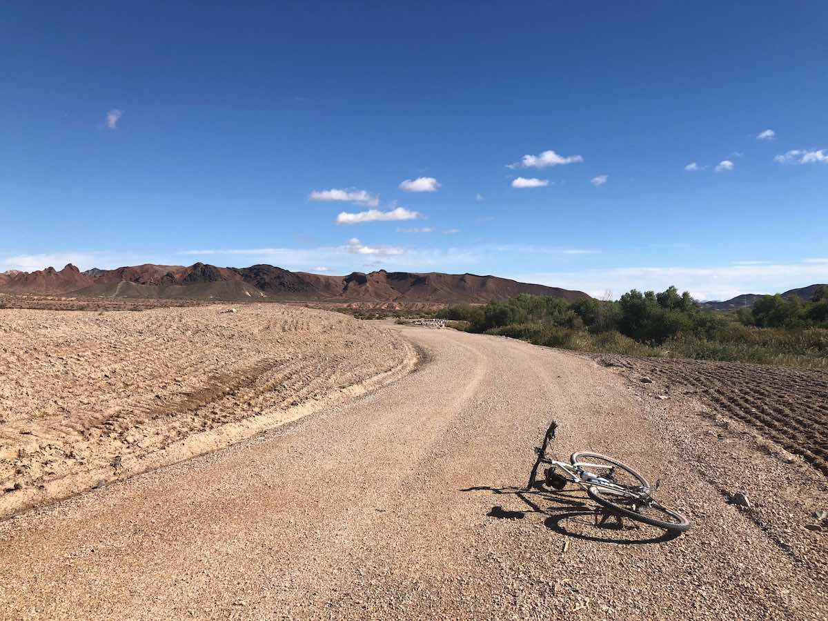 bikerumor pic of the day white bicycle laying on its side on a gravel road blue skies in the distance south of las vegas nevada.