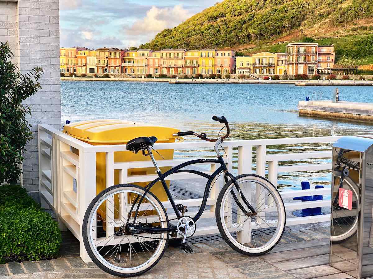 bikerumor pic of the day beach cruiser sitting in the marina overlooking a bay with townhomes below a small mountain in Canouan Island of Saint Vincent and the Grenadines.