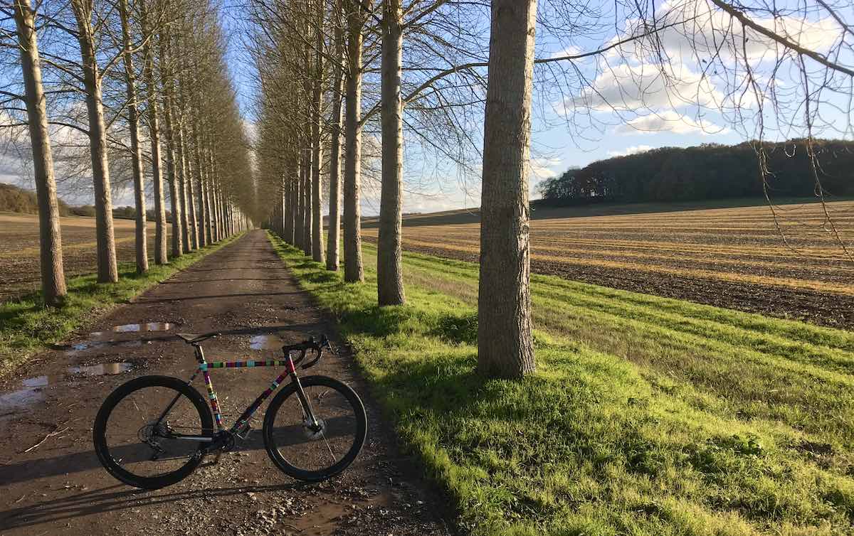 bikerumor pic of the day bicycle on a gravel path with a line of trees on either side and a field to the right, Near the village of Boxford, West Berkshire, England.