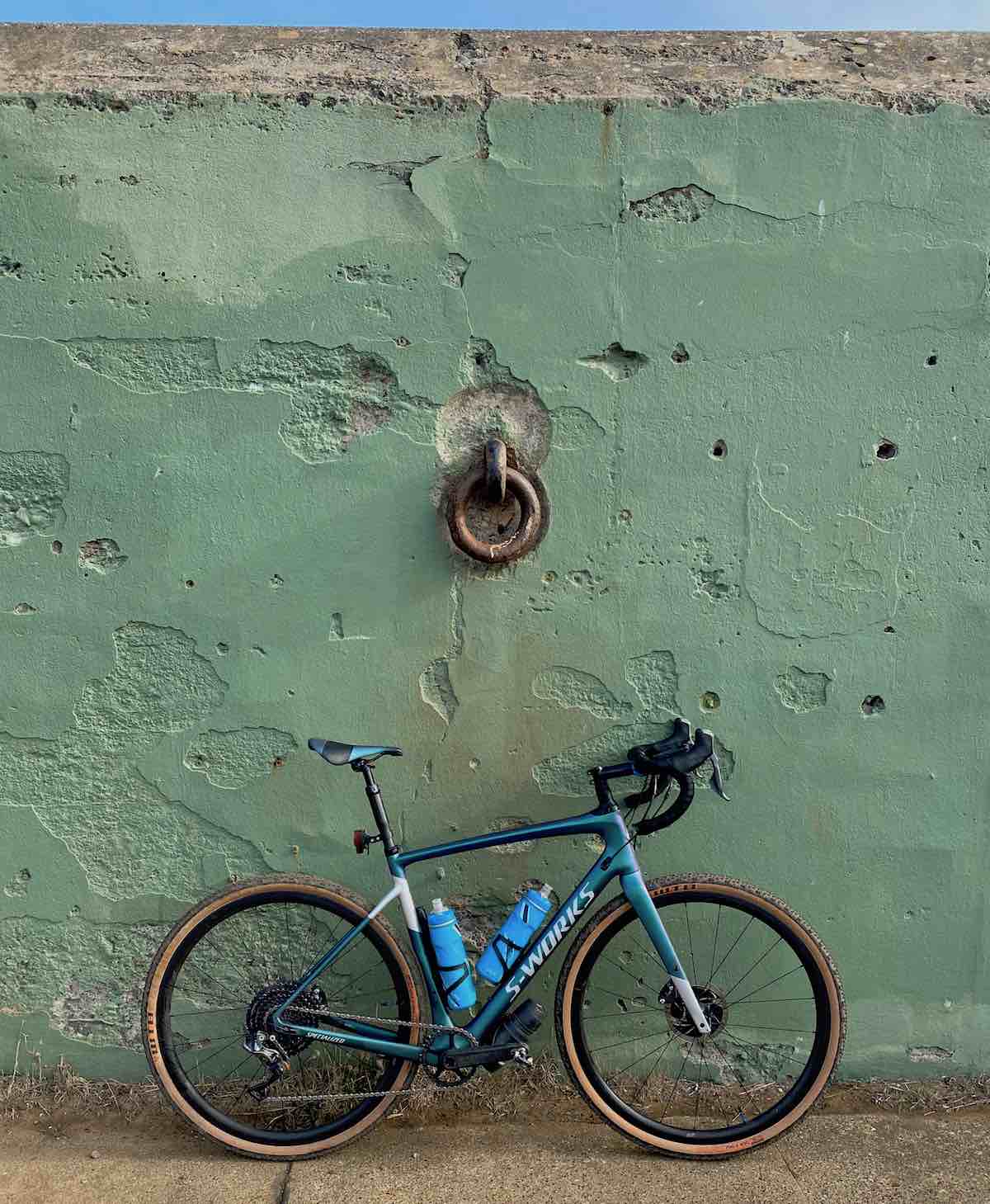 bikerumor pic of the day fort barry, battery mendell in the marin headlands, california. blue s-works bike up against a light green fortified wall with giant metal ring.