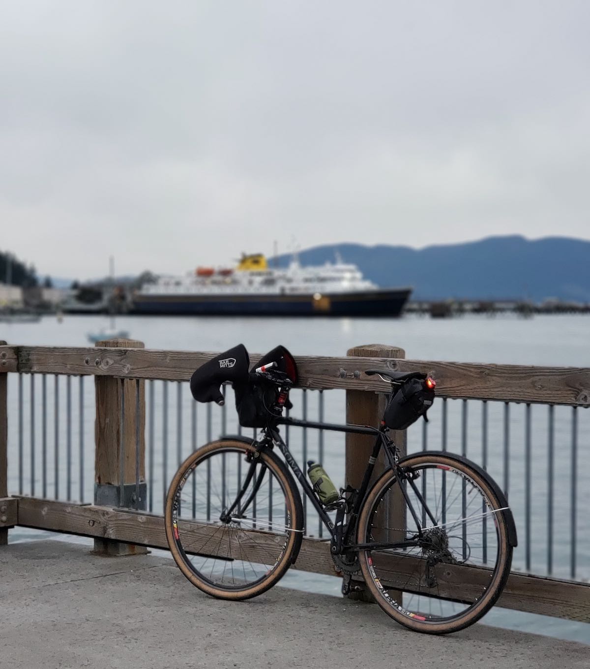 bikerumor pic of the day: touring bicycle leaning up against a fence overlooking the Alaska ferry in the terminal.