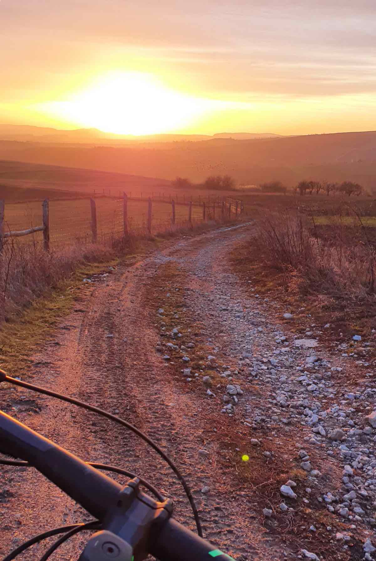 bikerumor pic of the day sunset in the horizon as mountain bike rides along dirt and gravel road in Slovakia, district Myjava.