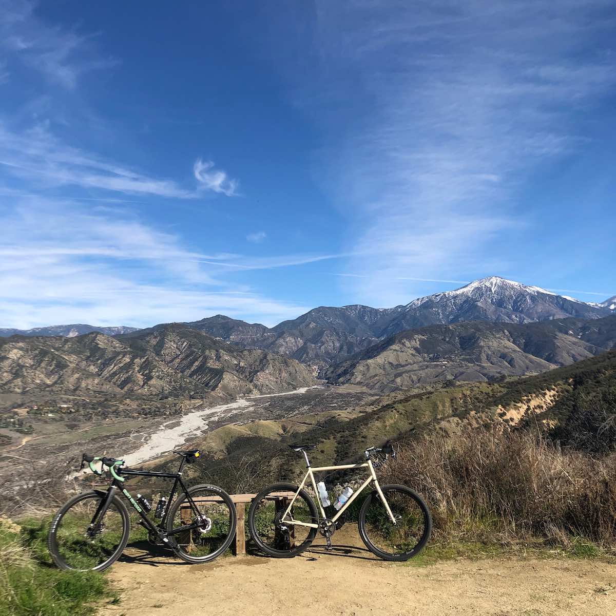 Bikerumor pic of the day winter in southern california two bicycles posed on a dirt path looking out over expansive mountains no snow in sight.