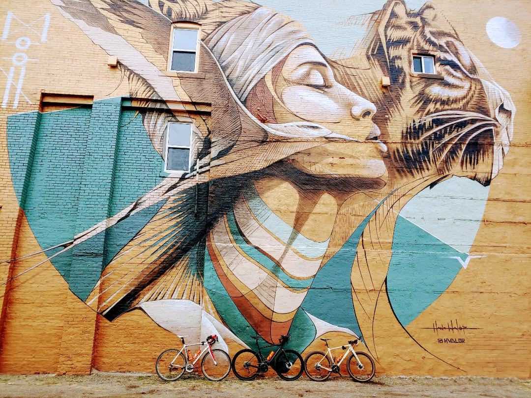 bikerumor pic of the day three bicycles in front of a giant mural of a bird a woman and a tiger in detroit michigan.