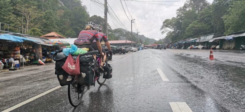 bikerumor pic of the day tandem cycling in malaysia during a downpour along a city street.