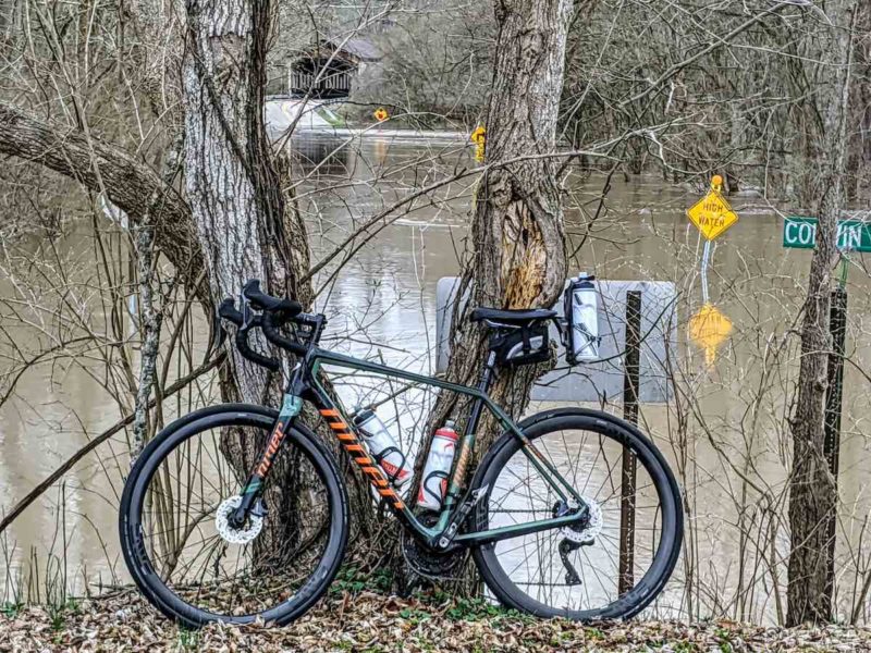 bikerumor pic of the day niner bicycle against a bare tree with a flooded street behind it on the little miami bike trail in southern ohio.