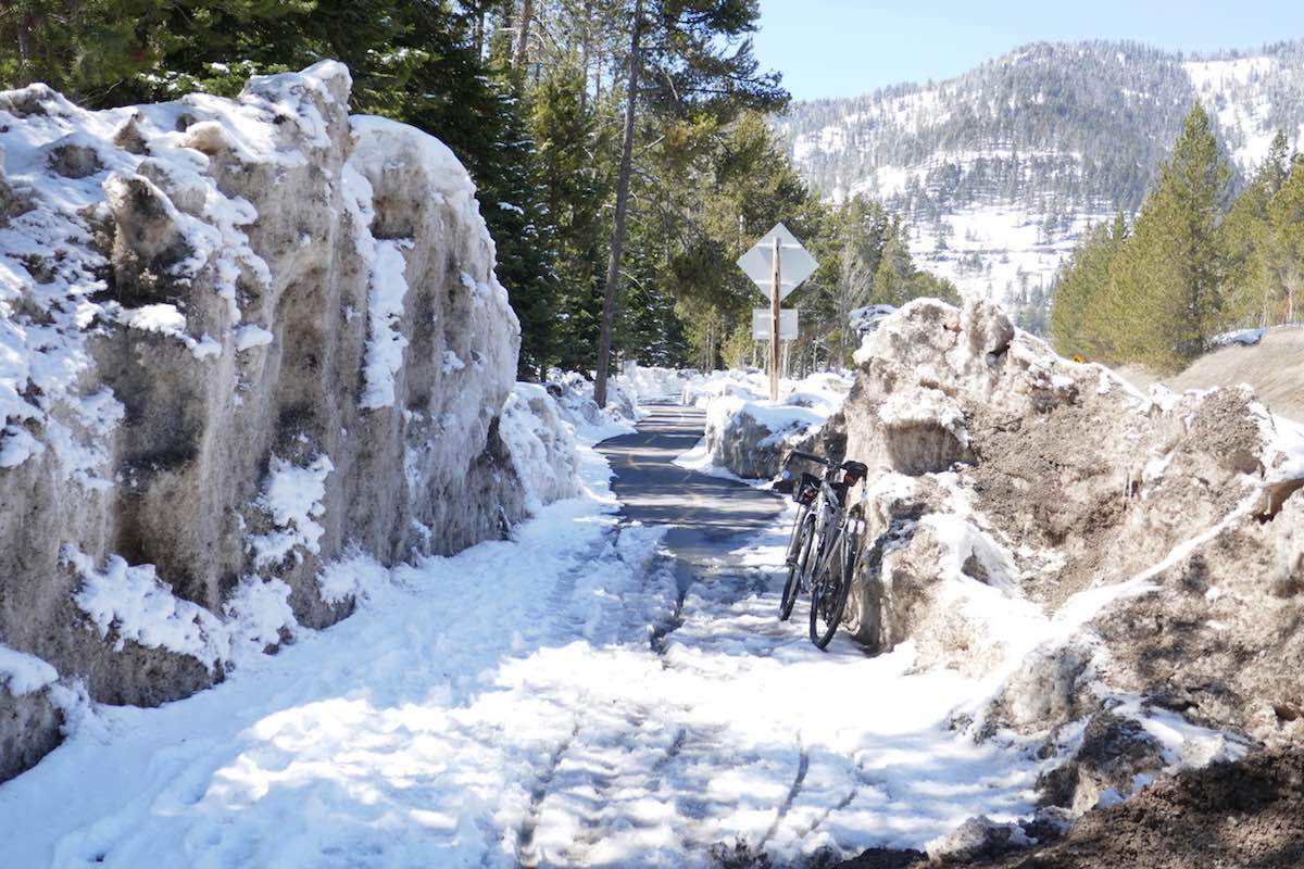 bikerumor pic of the day eriksen touring bike leaning against a rock on a snow covered section the teton pass in wyoming.