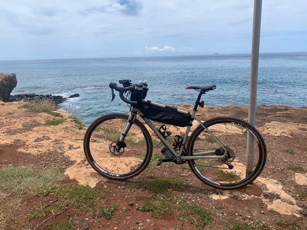 bikerumor pic of the day specialized bicycle on a rough sandy shoreline with ocean behind it and a ship in the distance off electric beach on oahu, hawaii.