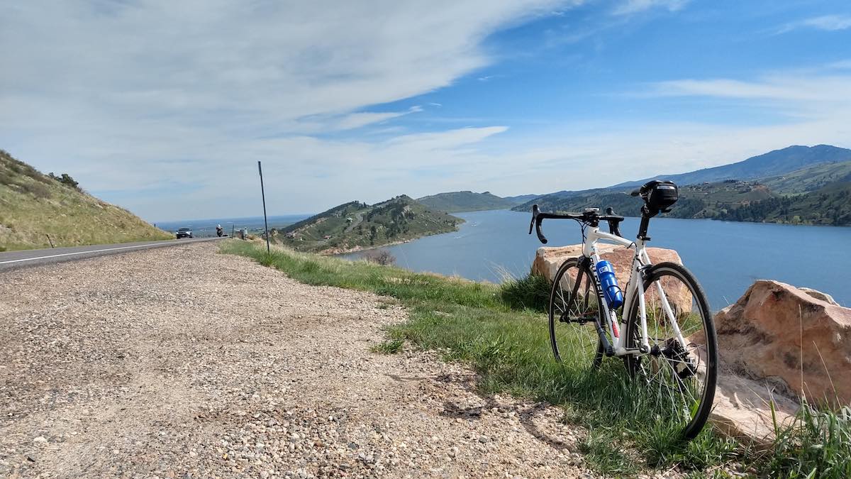 bikerumor pic of the day horse tooth reservoir on the right with road bike upright on the shoulder of a gravel path near fort collins colorado.