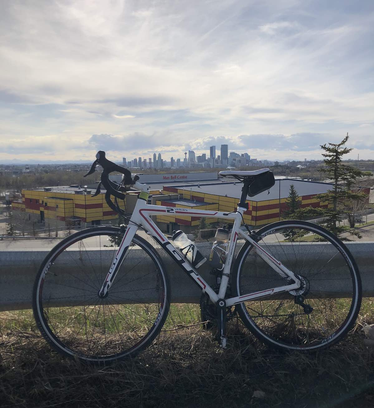 bikerumor pic of the day gt bicycle leaning against road barrier with the city of calgary alberta canada in the distance.