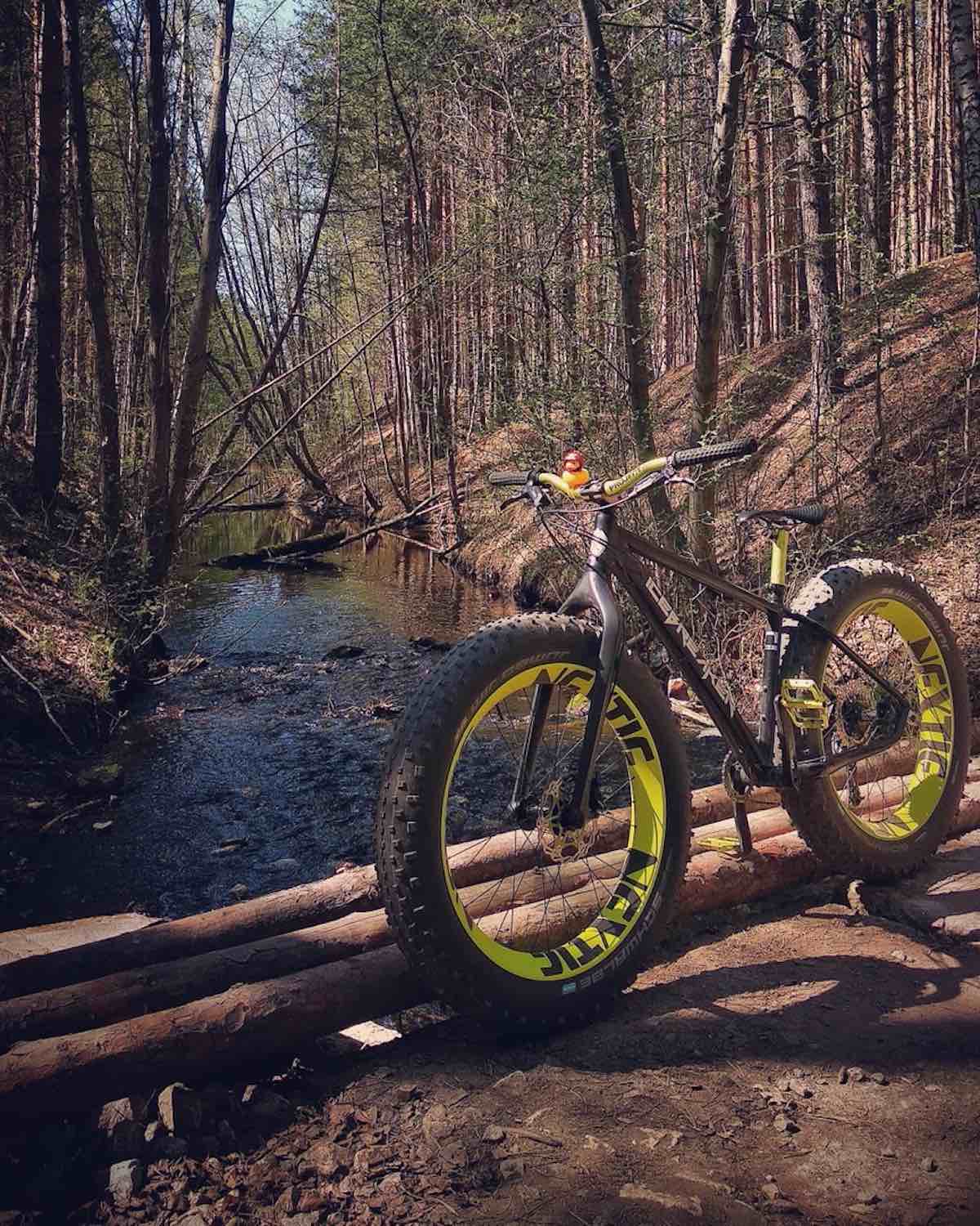 bikerumor pic of the day icebreaker fat bike with yellow rims on a bridge over a creek in the woods of Ekaterinburg, Russia