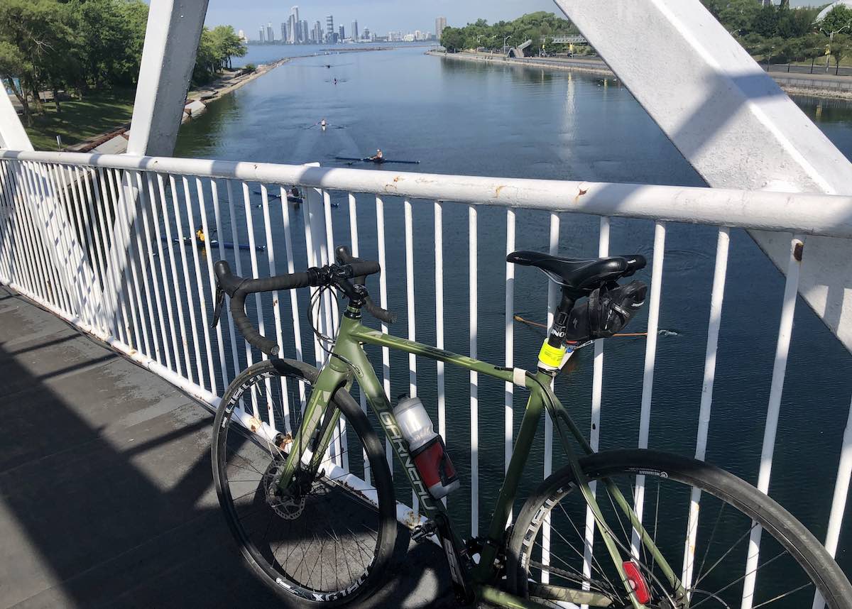 bikerumor pic of the day bicycle on a bridge overlooking the Toronto waterfront with rowers.