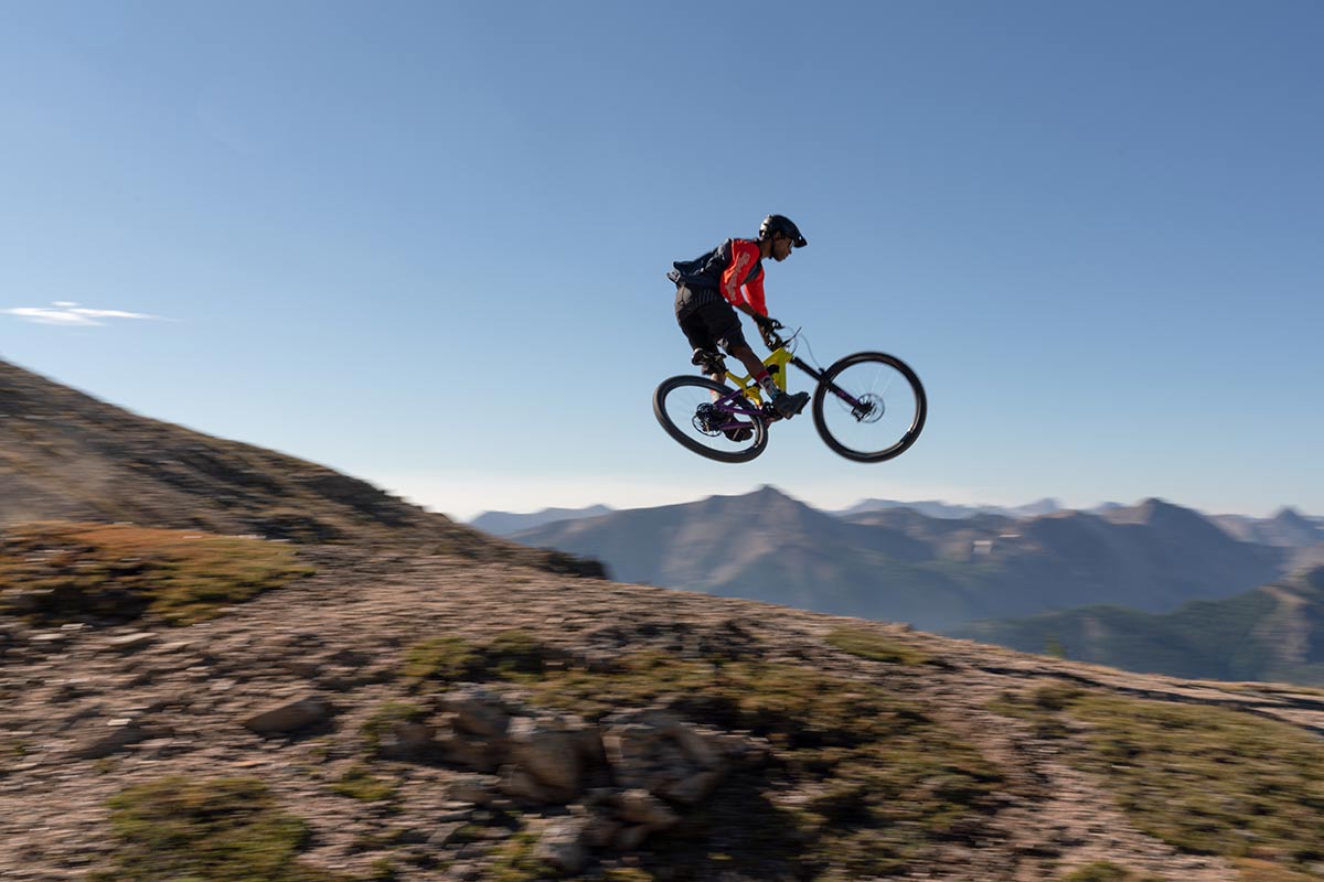 mountain biker sends salsa cassidy enduro bike into whip with epic mountain backdrop