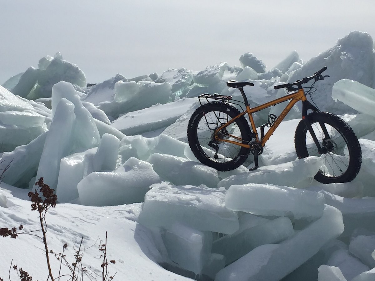 bikerumor pic of the day orange salsa fat bike on large slabs of broken ice piled up along the saint lawrence river in lachine quebec.