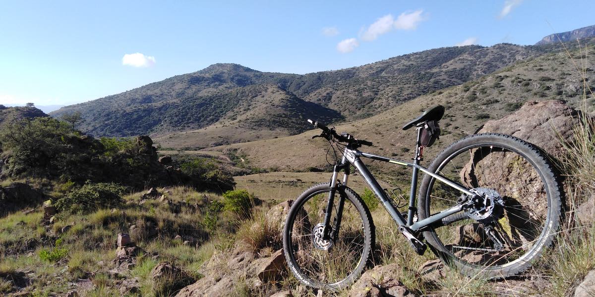 bikerumor pic of the day at the foot of the sierra de san miguelito near san luis potosi mexicao a mountain bike sits on a rocky outcropping at the base of a rocky mountain.