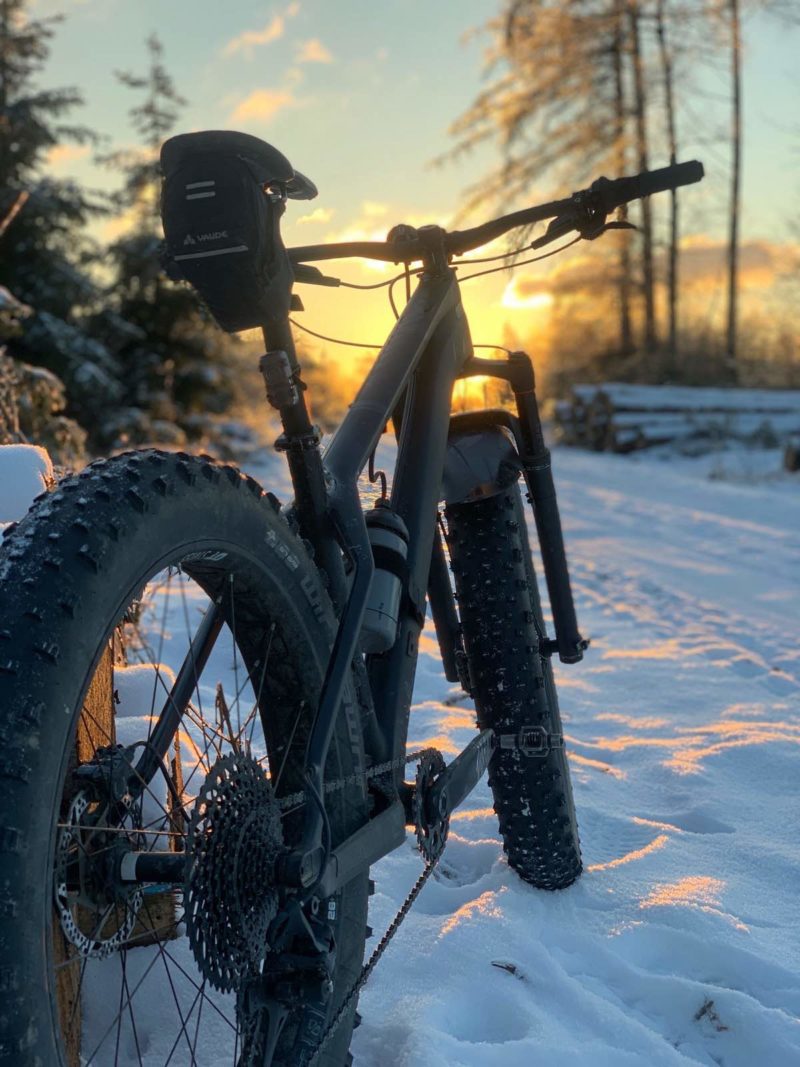 bikerumor pic of the day Drolshagen, Germany, an all black fat bike on a snowy trail with the sunset lighting up the sky