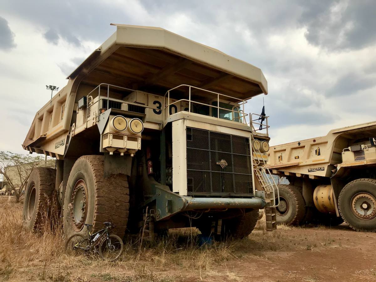 bikerumor pic of the day a bicycle leans agains the giant tire of a decommissioned dump truck in tanzania