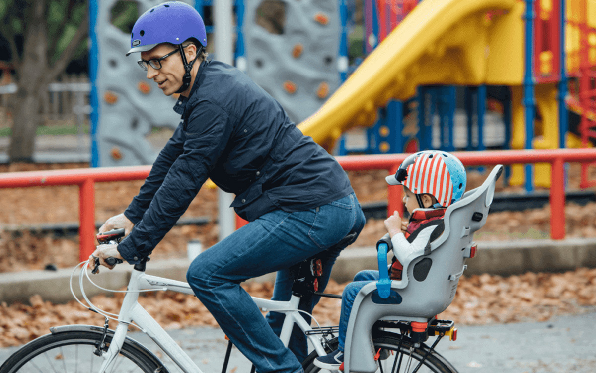 Father and child on bike wearing nutcase helmets