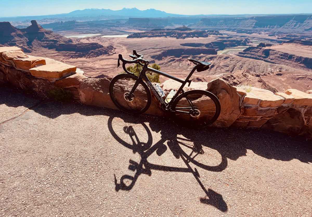 a bicycle at the top of a ridge in moab utah looking out over a red rock valley