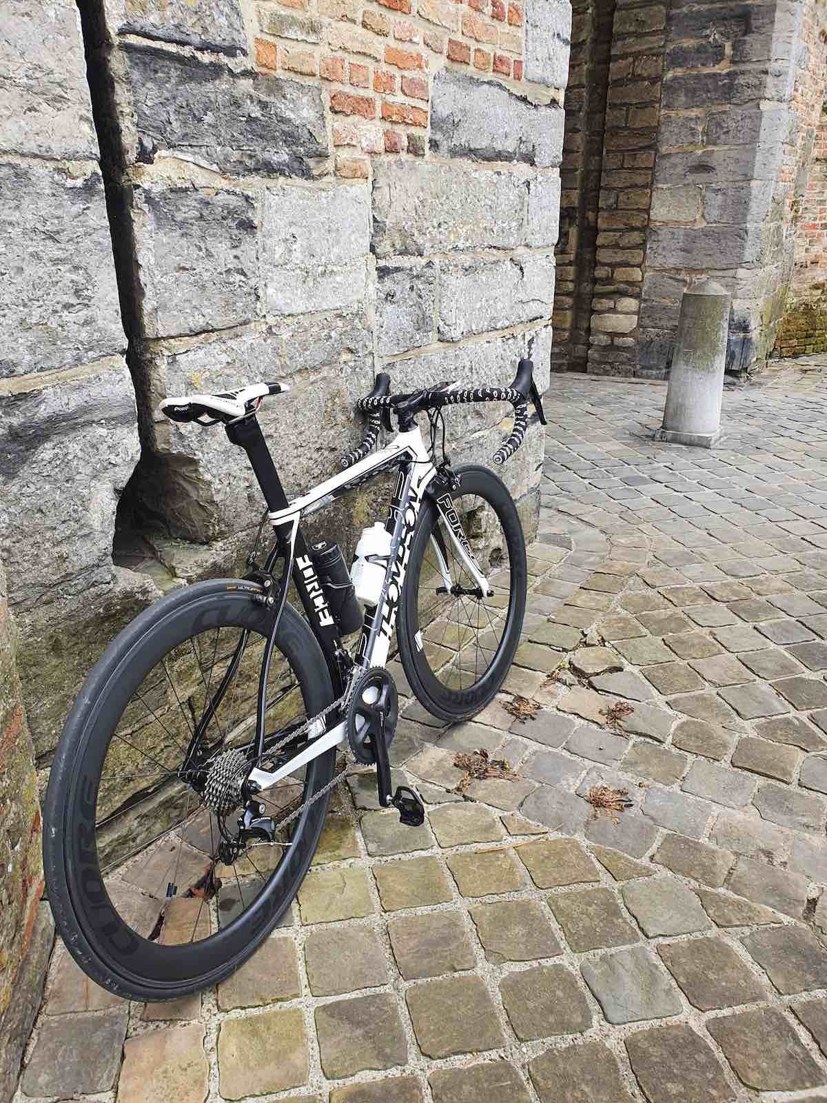 bikerumor pic of the day a bicycle leans against a stone wall and is surrounded by cobble stones in brugge, belgium.