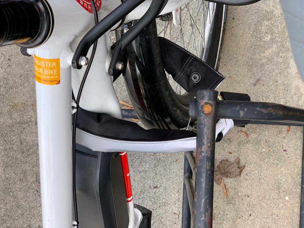 a bicycle chain lock shown stretched to the max to fit around wheel, frame and rack