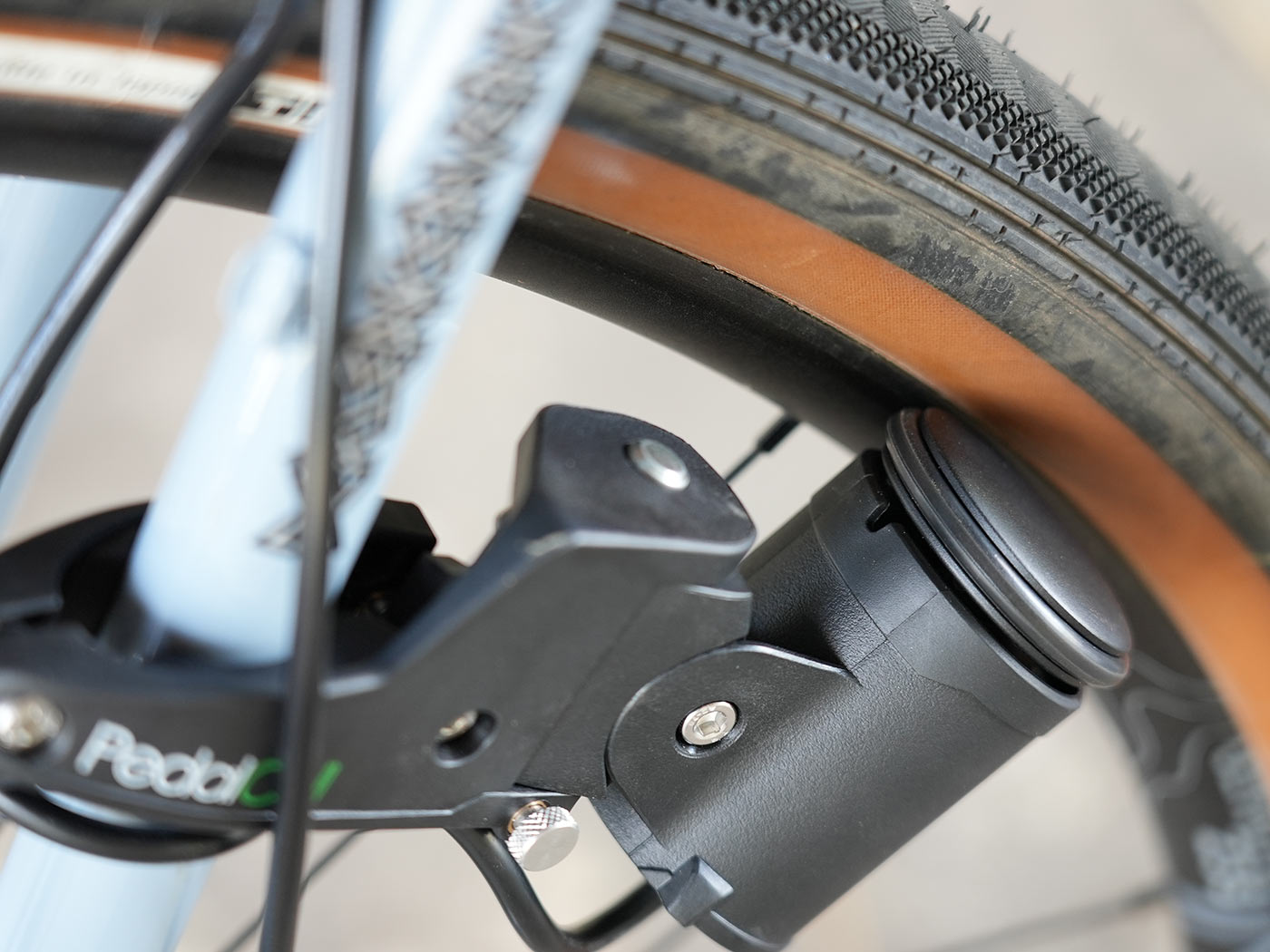 review of pedalcell rim dynamo shown closeup making contact with bicycle wheel rim