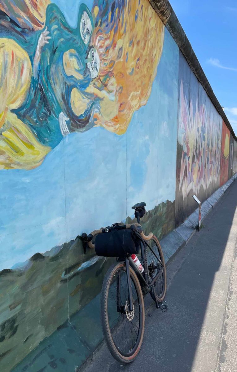 bikerumor pic of the day a bicycle leans against a piece of the former berlin wall that has been painted with colorful graffiti.