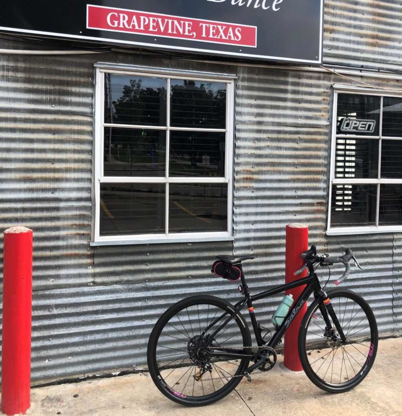 bikerumor pic of the day a bicycle leans against a short red pillar next to a building with corrugated metal siding in grapevine texas.