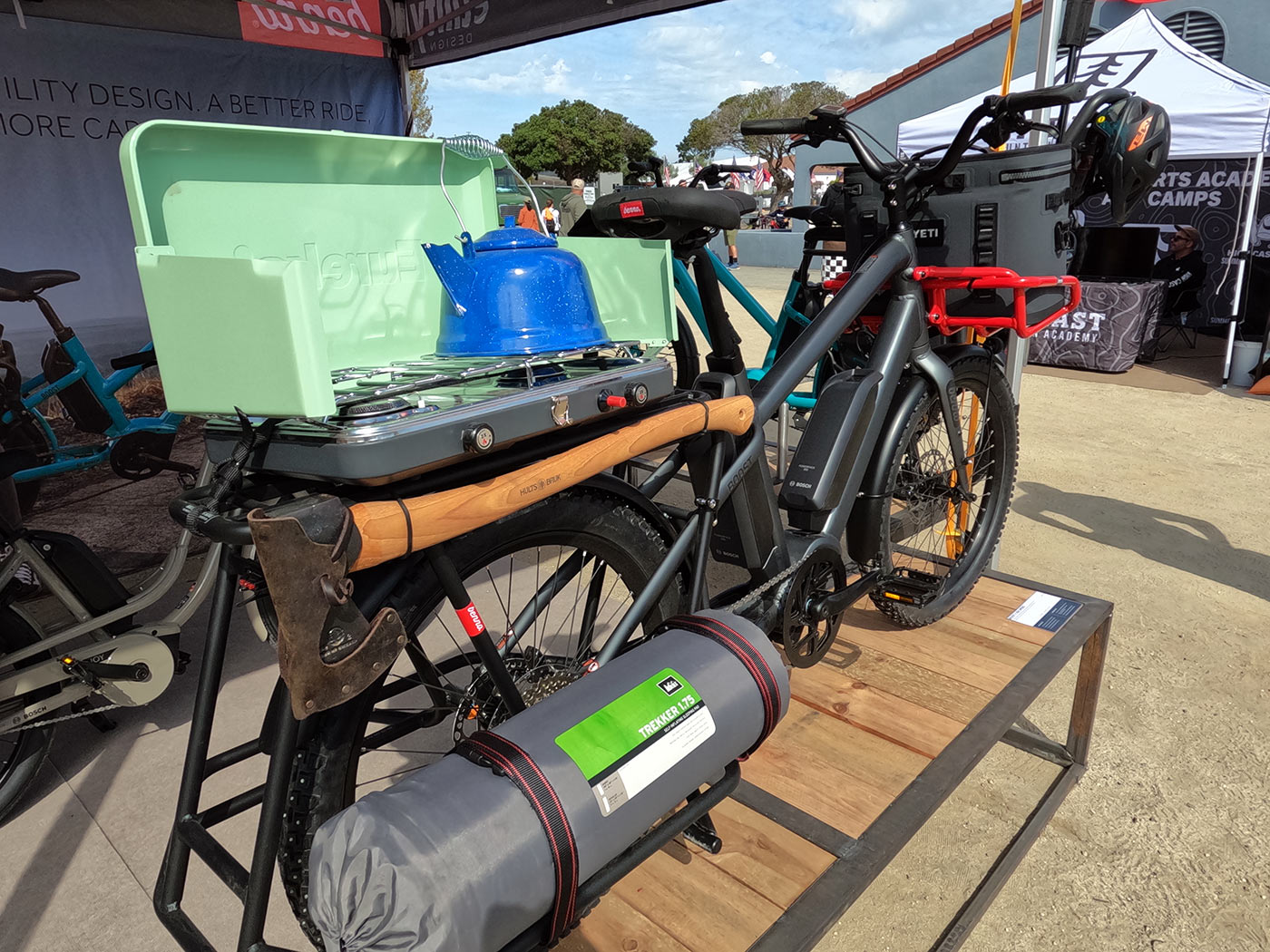 benno boost e-cargo bike with studded mountain bike tires and overlanding setup with stove and axe