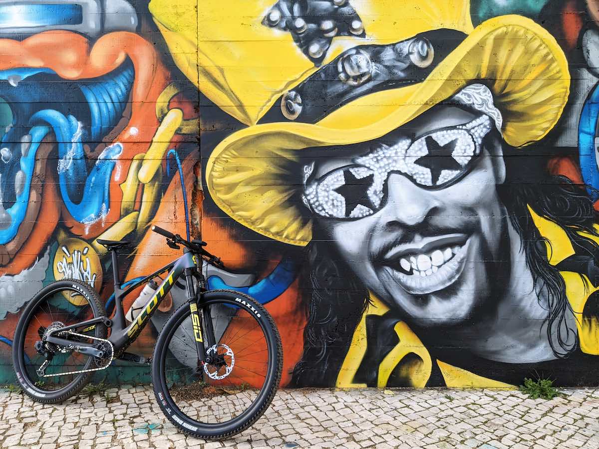 bikerumor pic of the day a scott spark bicycle leans against a wall of colorful graffiti.