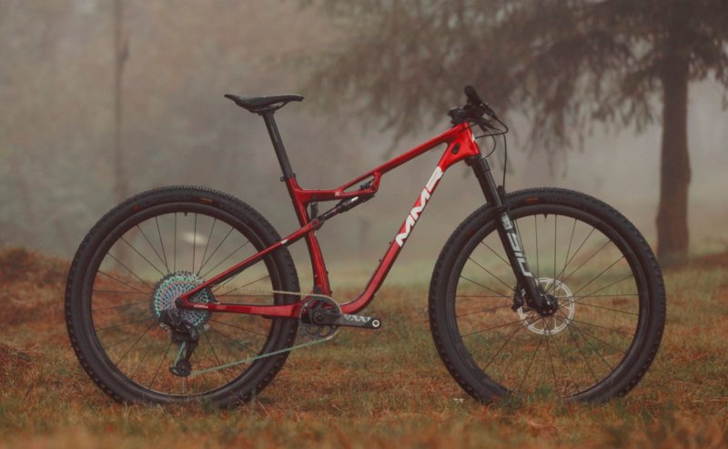 Photo of Kenta SL in red in a foggy forest. Side view.
