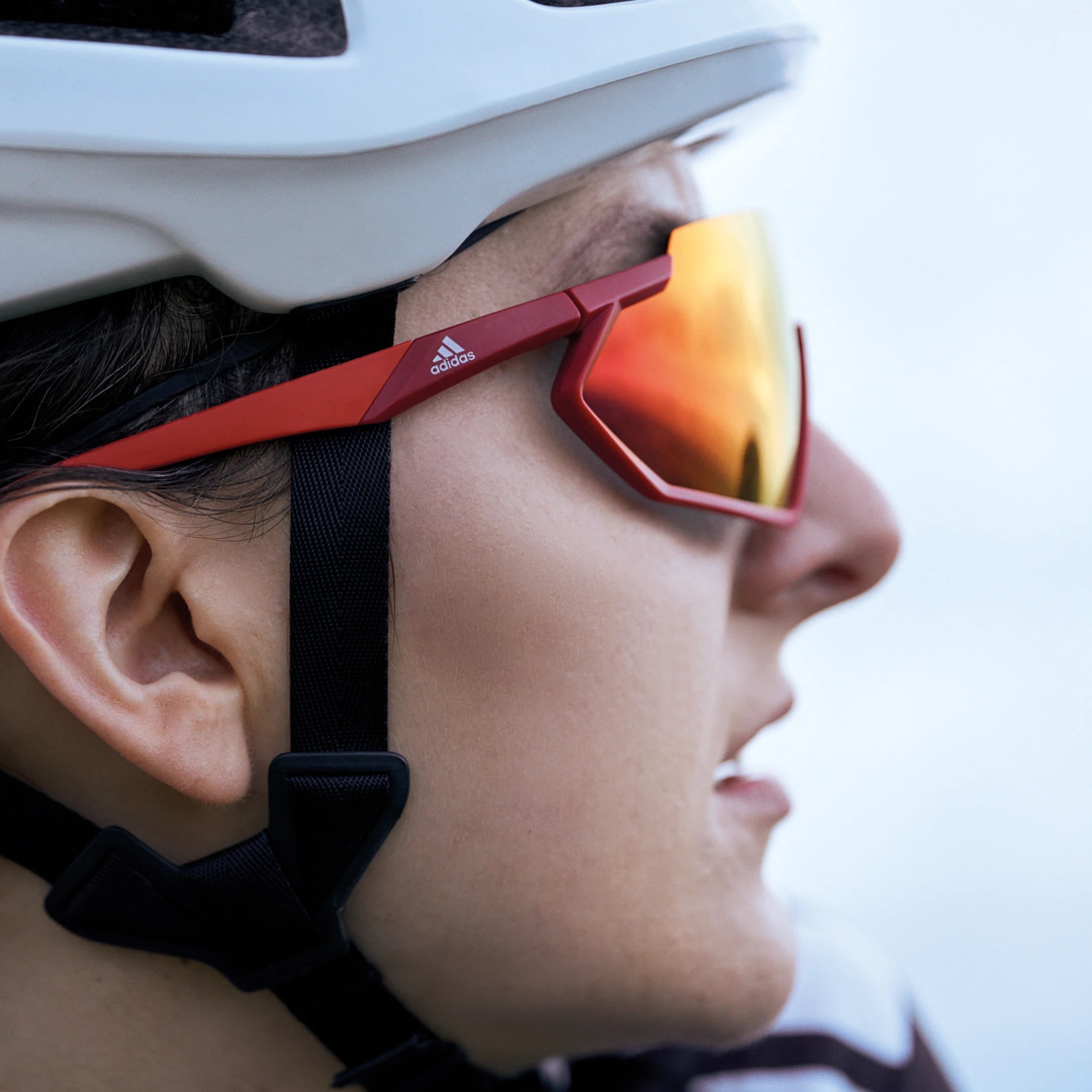 A woman wearing Adidas SP0041 sunglasses. Side view.