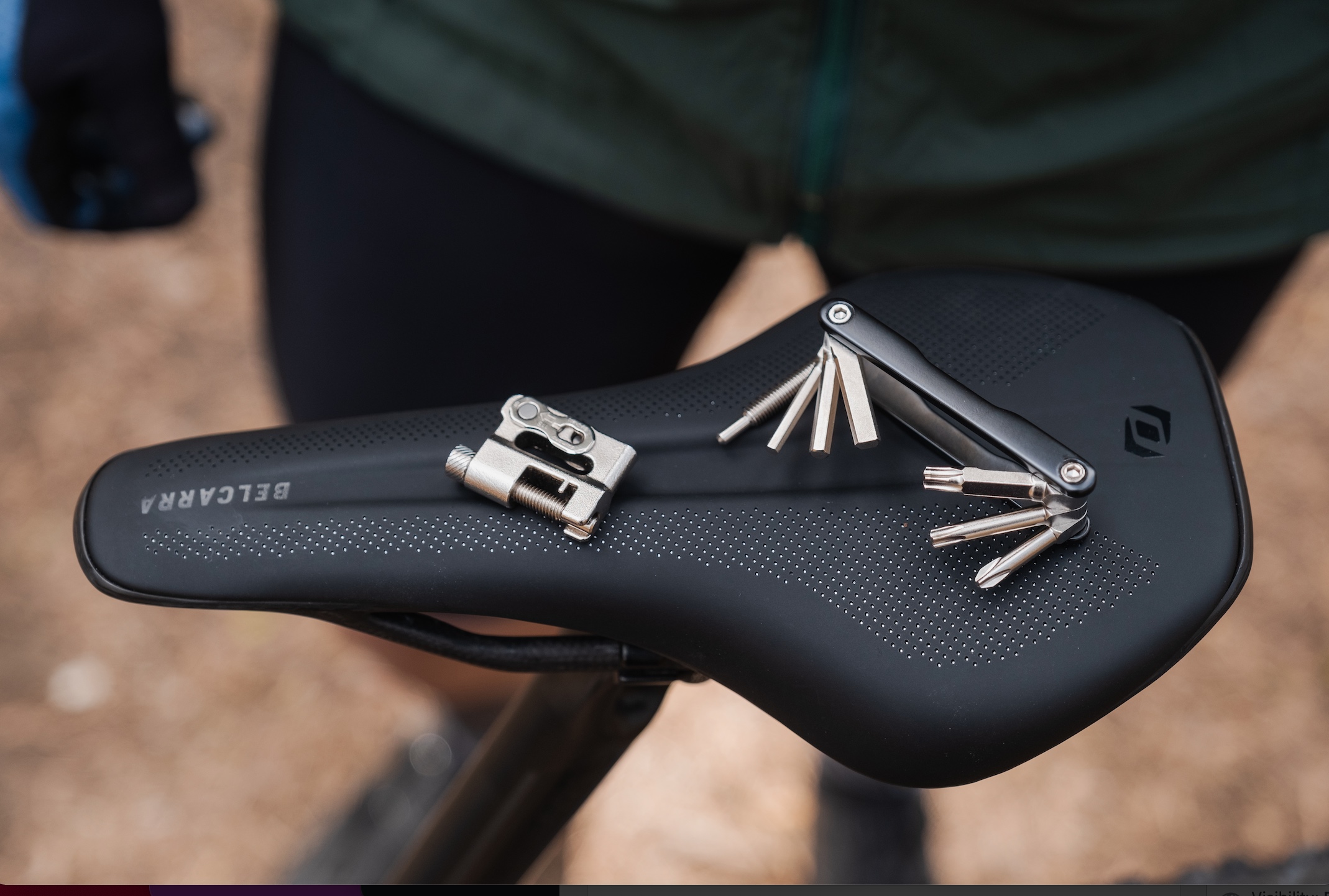 The Syncros Cache integrated storage bottle cage tool set sitting on a saddle.