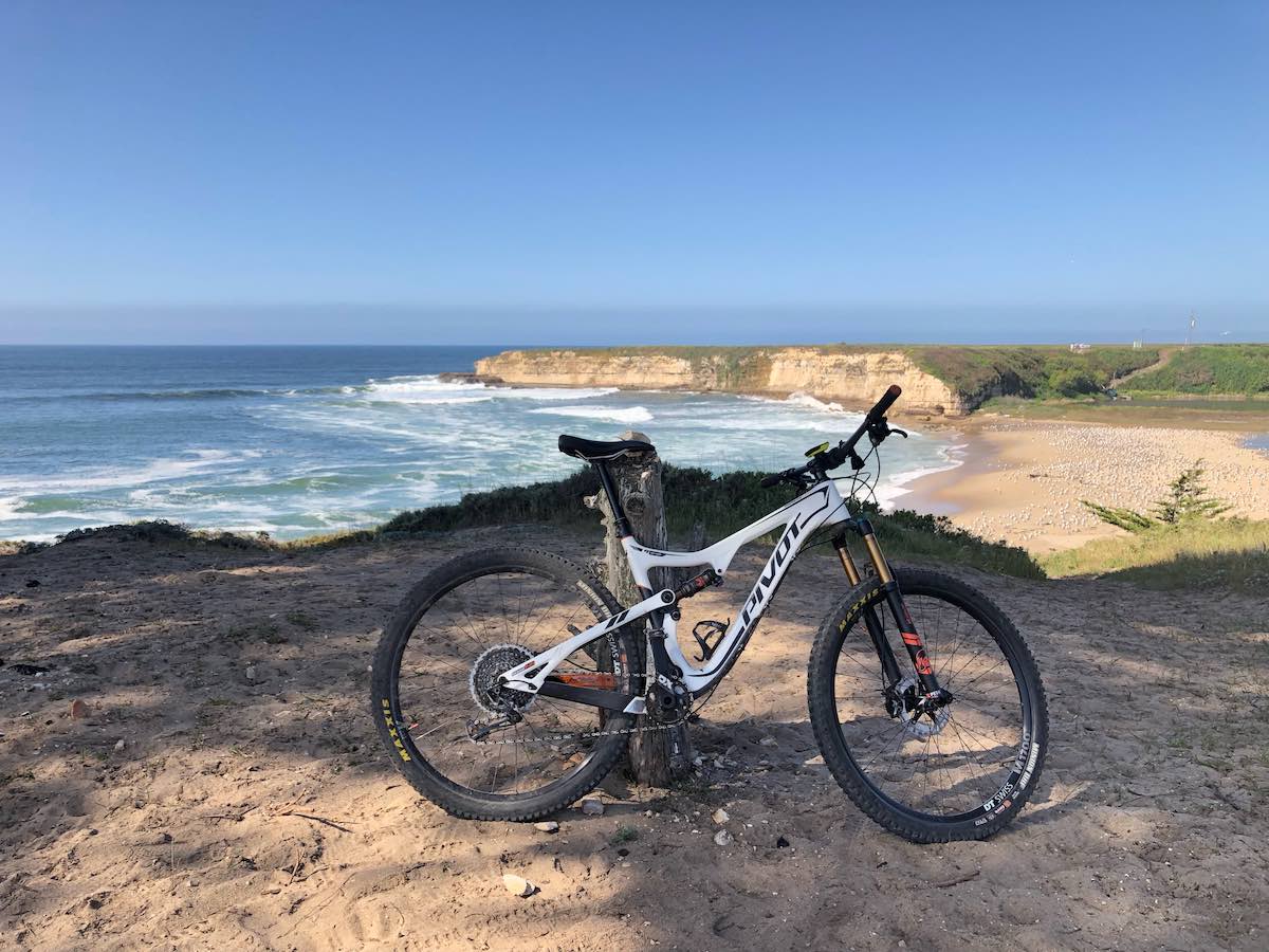 bikerumor pic of the day a mountain bike leans against a wood fence post on an outcropping overlooking a bay