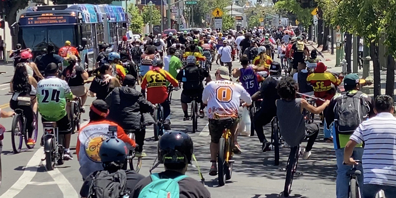 A large crowd riding bikes at the Oakland rideout.