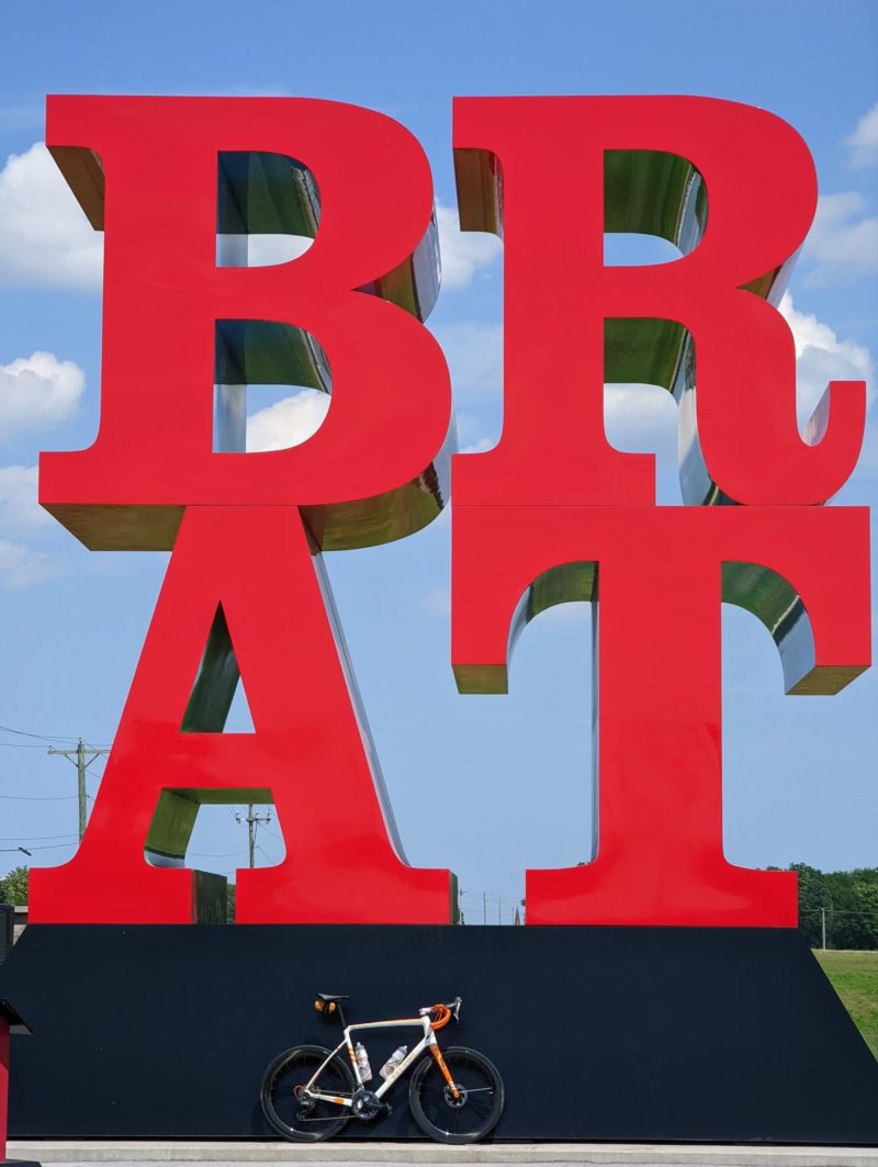 bikerumor pic of the day a bicycle is posed in front of a giant red BRAT sign in Sheboygan Falls, Wisconsin.