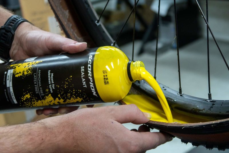 pirelli yellow tubeless sealant being poured into a mountain bike tire