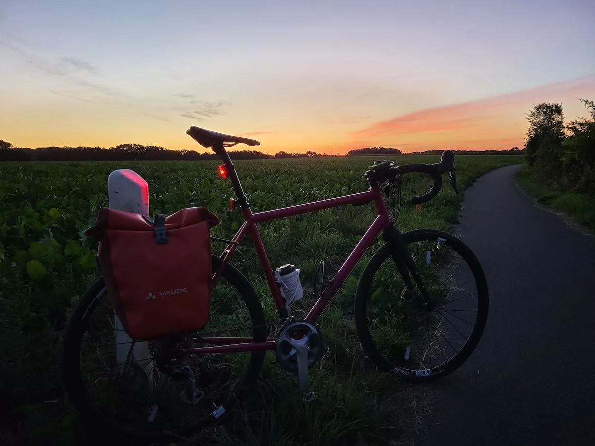 bikerumor pic of the day a bicycle is in a field alongside a path as the sun rises