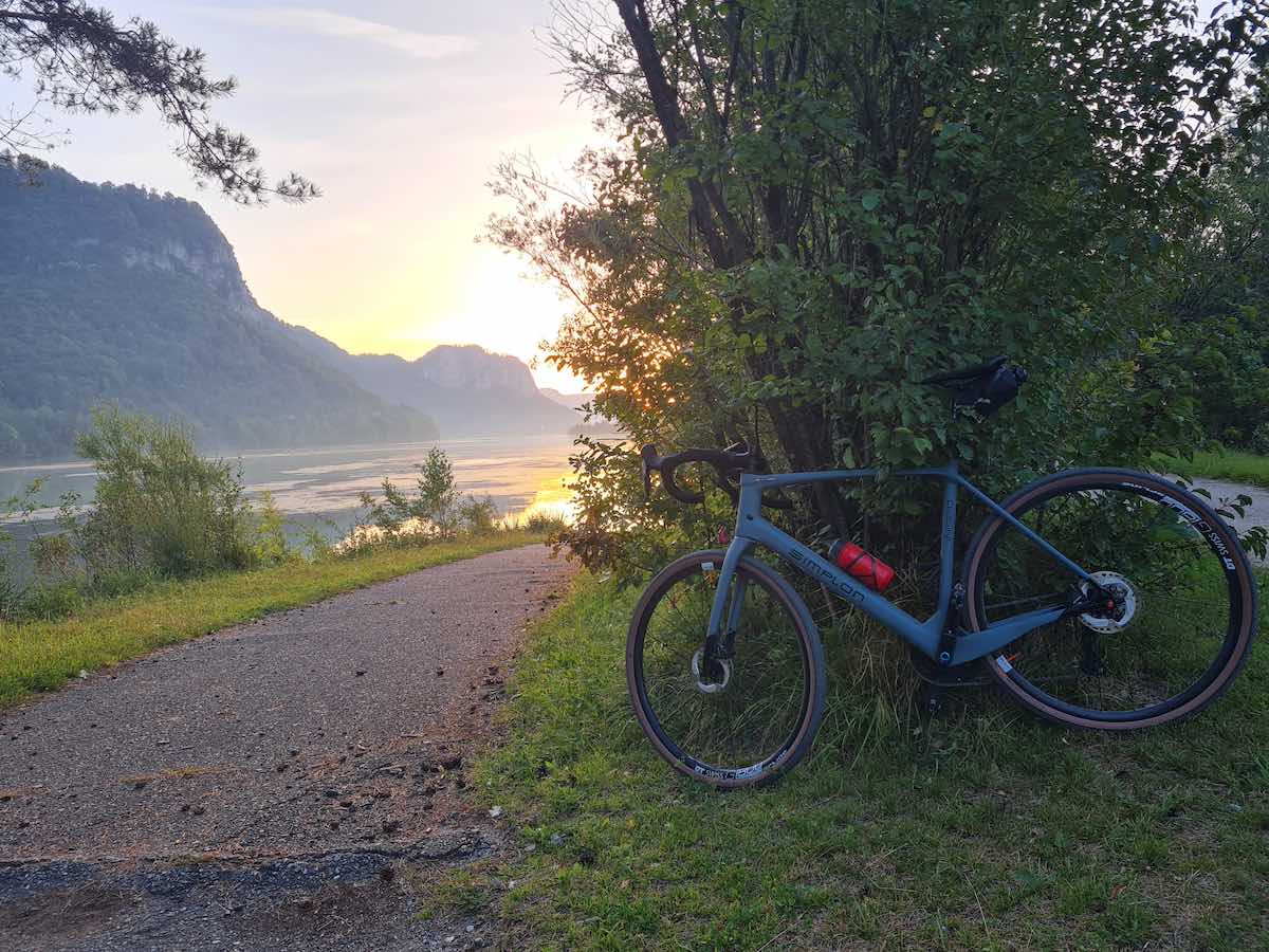 bikerumor pic of the day a bicycle leans against a small tree along a path leading towards the sunrise