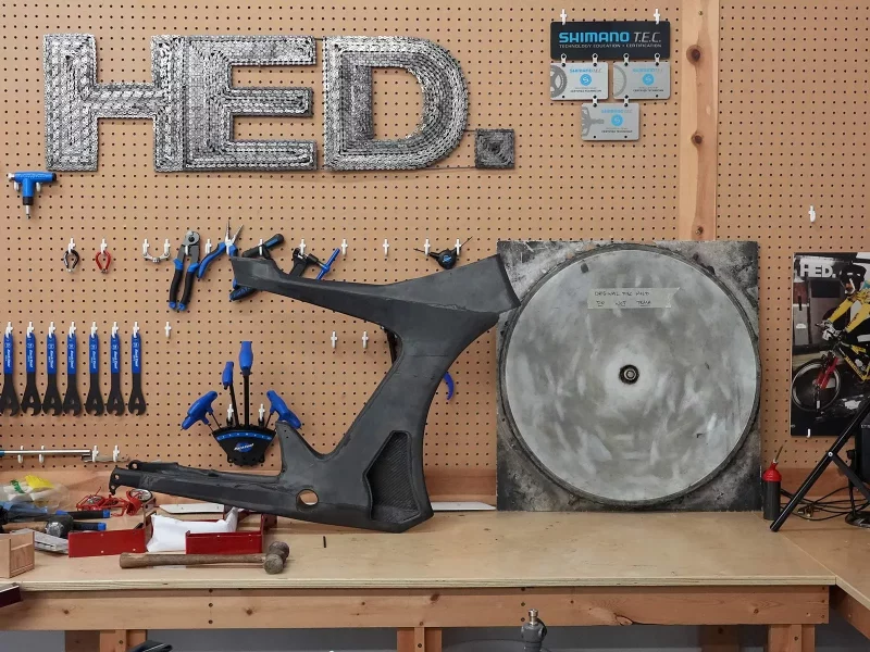 HED cycling factory tour shows a workbench with the logo made of bicycle chains