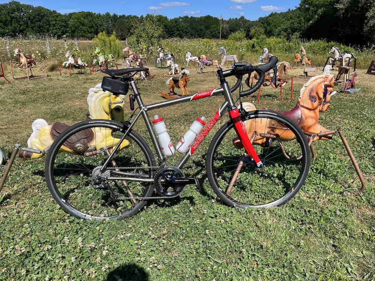 bikerumor pic of the day a bicycle is posed in front of a bunch of toy horses on a grassy field