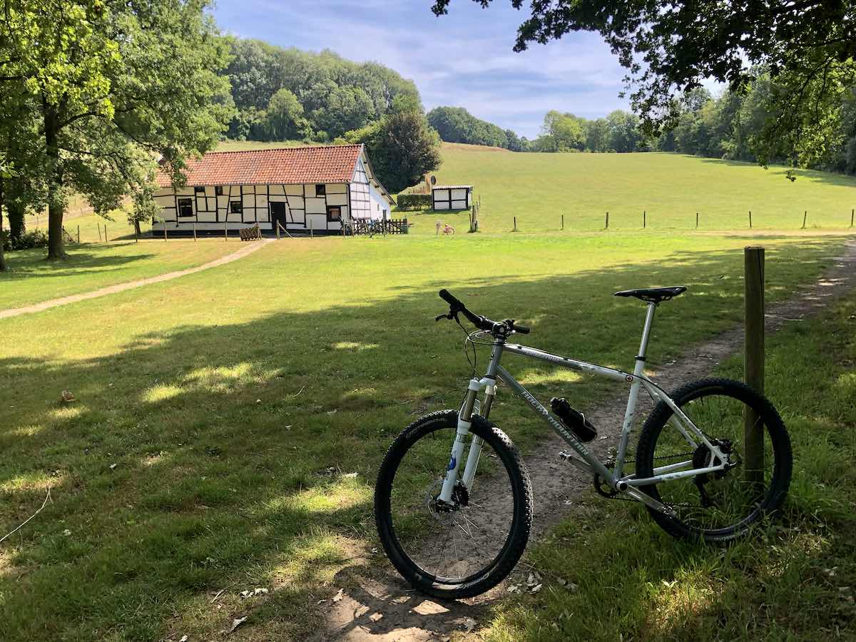 bikerumor pic of the day a bicycle leans against a post next to a dirt trail along a green field with a dutch barn nearby