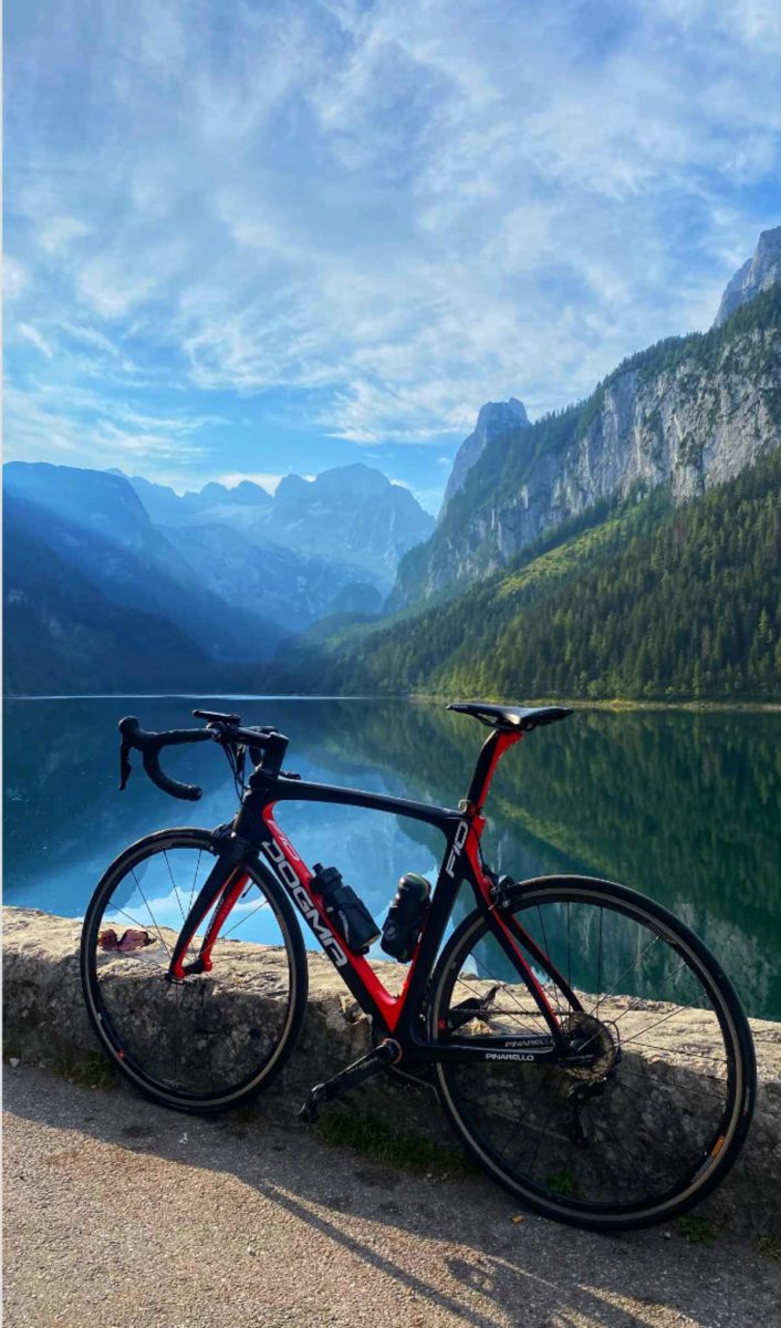 bikerumor pic of the day a road bike leans against a low stone wall overlooking a large clear lake surrounded by tall mountains